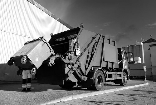 Crew handling commercial bins during a daytime collection
